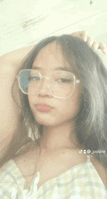a girl wearing glasses and a plaid shirt is taking a selfie with the hashtag @_cool_