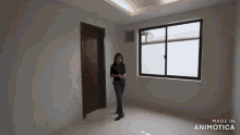 a woman is standing in an empty room with a window and door .