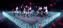 a group of women are dancing on a stage in front of a projector screen .