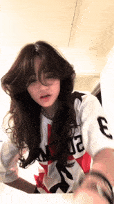 a girl with long hair is wearing a jersey with the number 3 on it
