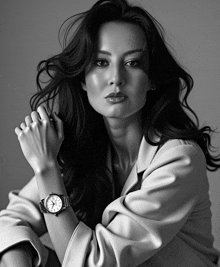 a black and white photo of a woman with a watch on her wrist that shows the time as 10:10