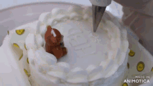 a cake is being decorated with whipped cream and a brown teddy bear