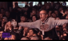 a man wearing a sweatshirt with the word nautica on it stands in front of a crowd of people