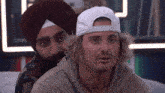 a man wearing a turban and a white hat with the word reebok on the front