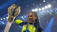 a woman holding a wrestling championship belt with the letters n on the bottom
