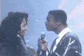 a man and a woman are kissing in front of a microphone that says vine on the bottom