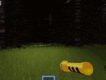 a yellow flashlight is sitting in the grass in a dark forest