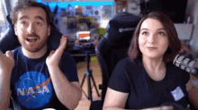a man and a woman are sitting in front of a microphone .