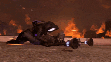 a person is laying on the ground in front of a large fire
