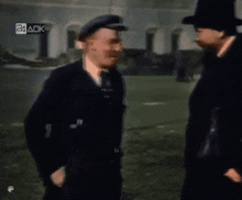 two men are standing next to each other and one has a briefcase .