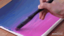 a person is painting a purple and blue gradient on a canvas with a brush .