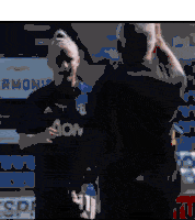 a man wearing an aon jersey is giving a high five to another man