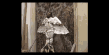 a painting of a man with wings is being held up by people .