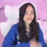 a woman is sitting in a chair wearing a hat and a blue sweater .
