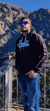 a man wearing sunglasses and a hoodie that says ' bucks ' on it