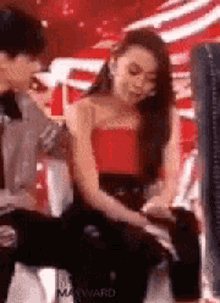 a man and a woman are sitting next to each other .