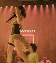 a woman in a corset is dancing in a dark room with red lights
