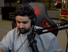 a man wearing headphones is sitting in front of a microphone .