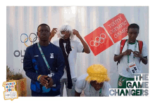 a group of people standing in front of a youth olympic games sign
