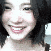 a close up of a woman 's face smiling with her teeth showing .