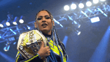 a woman is holding a wrestling championship belt in her hand