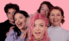 a group of people are posing for a picture with one woman with pink hair