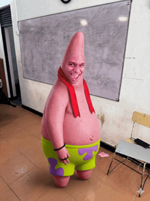 a man dressed as patrick star stands in front of a white board