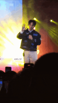 a blurry photo of a man on a stage with mlcf written on the bottom