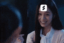 a woman with long hair is smiling and holding a cigarette in her hand while another woman looks on .
