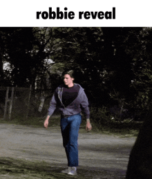 a picture of a man walking down a road with the words robbie reveal below him