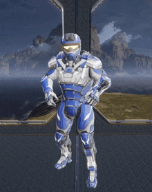 a man in a blue and white armor stands in front of a mountain range