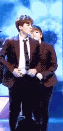 a man in a suit and tie stands next to a woman