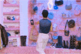 a man is standing in front of a wall of handbags and shoes