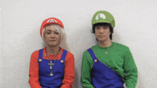 two men dressed up as mario and luigi are sitting next to each other