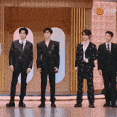 a group of men in suits are standing in front of a sign that says ' ao ' on it