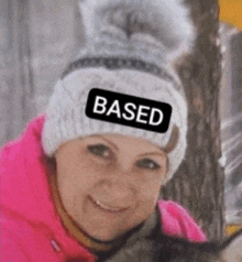 a woman wearing a hat with a sticker that says based