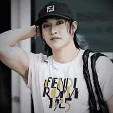 a man wearing a fendi roma 1925 t-shirt and a hat