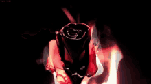 a red rose is burning in the dark and smoke is coming out of it .