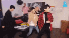 a group of young men are dancing together in a room .