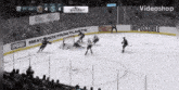 a hockey game is being played in a stadium with advertisements for impossible meat made from plants