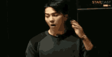 a man is making a funny face with his mouth open and his hands in the air .