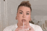 a woman wearing a white t-shirt and hoop earrings is making a funny face .