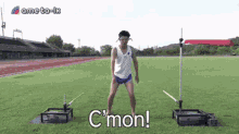 a man in a white shirt and blue shorts is standing on a grassy field with the words c'mon written below him