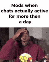 a man in a red hoodie is sitting in a chair holding a video game controller and making a funny face .
