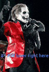 a man in a red suit is singing into a microphone