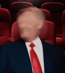 a blurry picture of a man in a suit and tie in a theater