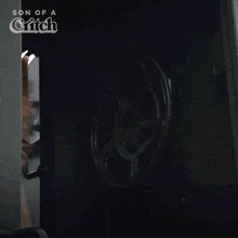 a man standing in a dark room with the words son of a glitch on the bottom
