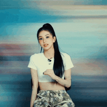 a woman wearing a white nike crop top and camo pants