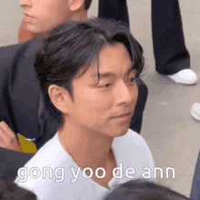 a close up of a man 's face with the words gong yoo de ann written on it