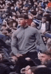 a man is standing in front of a crowd of people at a stadium .